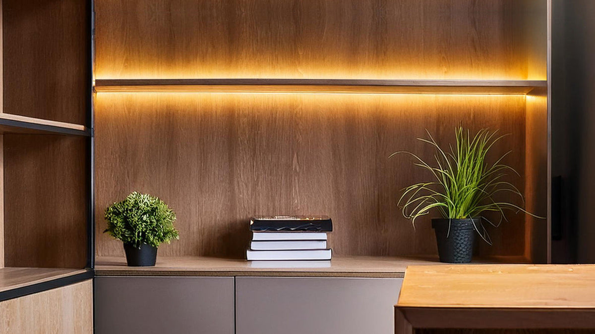 Rear-mounted linear lighting illuminating a wood-finished cabinet and shelves.